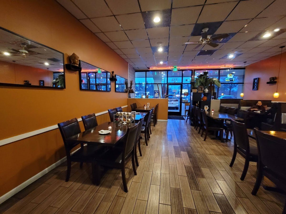 Warm dining room with wooden floors and booth seating inside Kindee Thai Restaurant