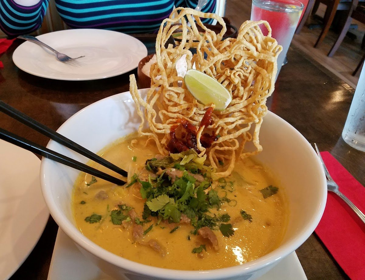 Bowl of Khao Soi curry noodle soup topped with crispy egg noodles at Kindee Thai
